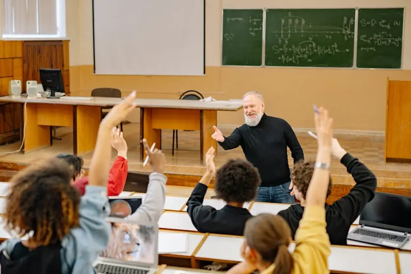 Um grupo de alunos levantando a mão para participar na aula.