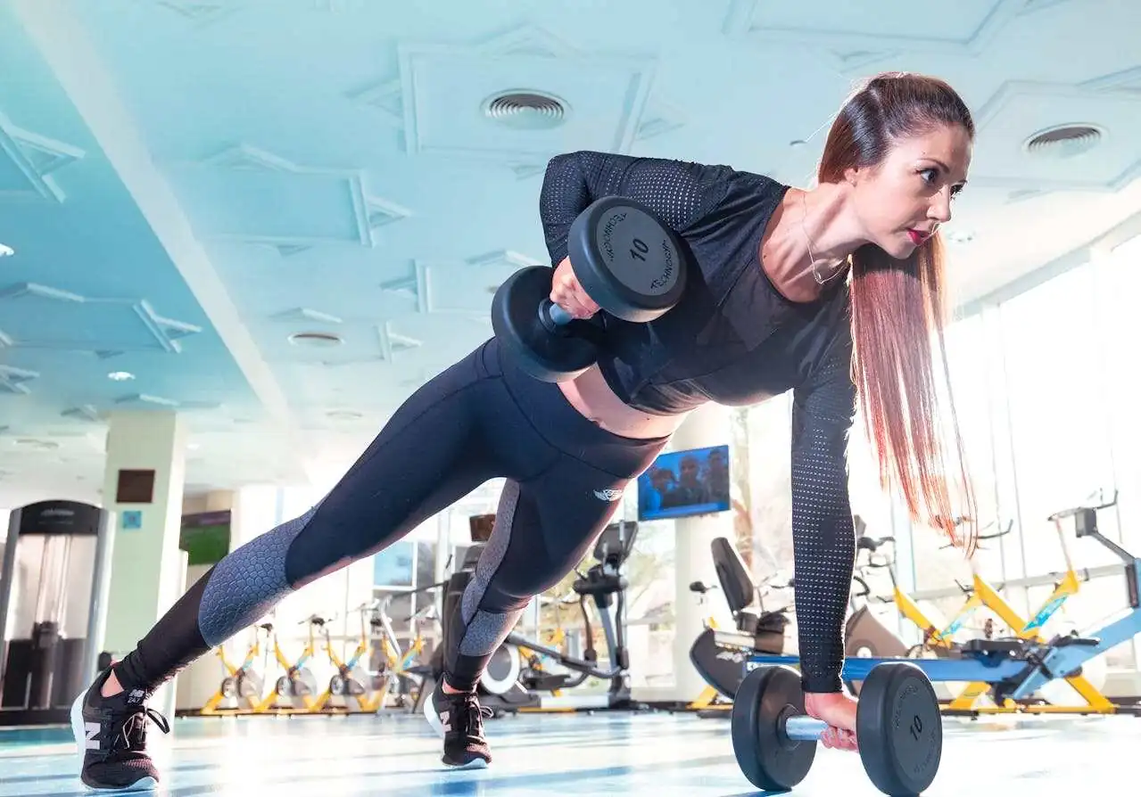 time-tracking-best-practices-fitness-gym Woman exercising in a gym.