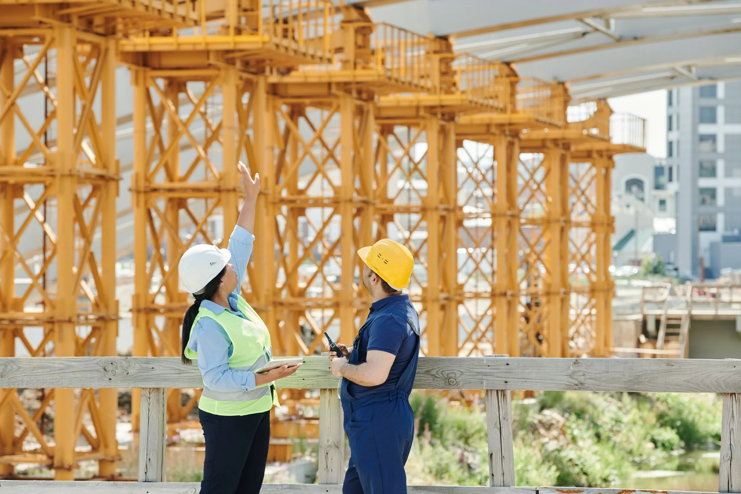 Two workers standing in front of a construction site.