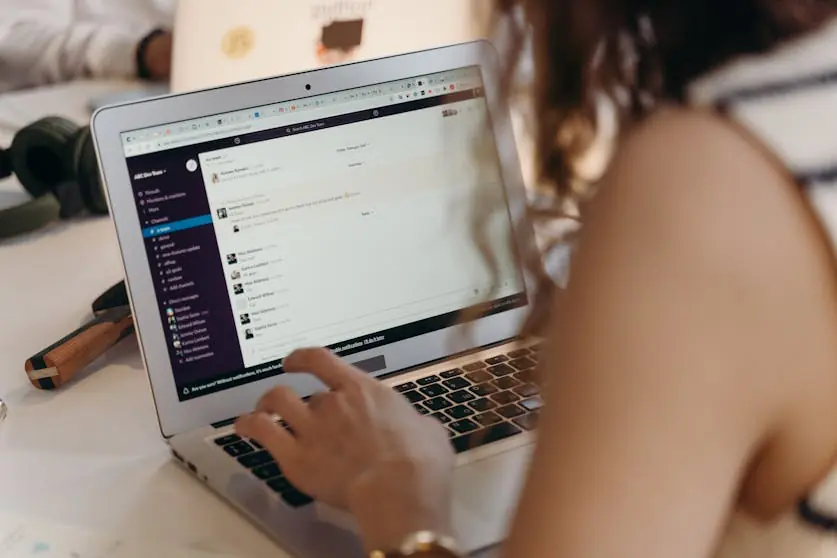 Woman using Slack on a latop.