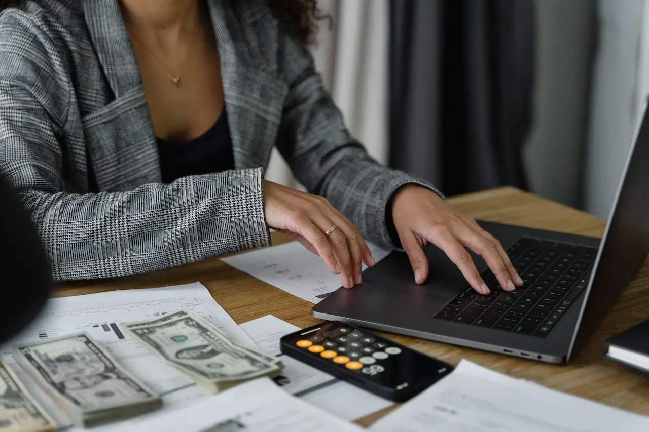 Une femme analysant les revenus de l'entreprise et travaillant sur son ordinateur portable