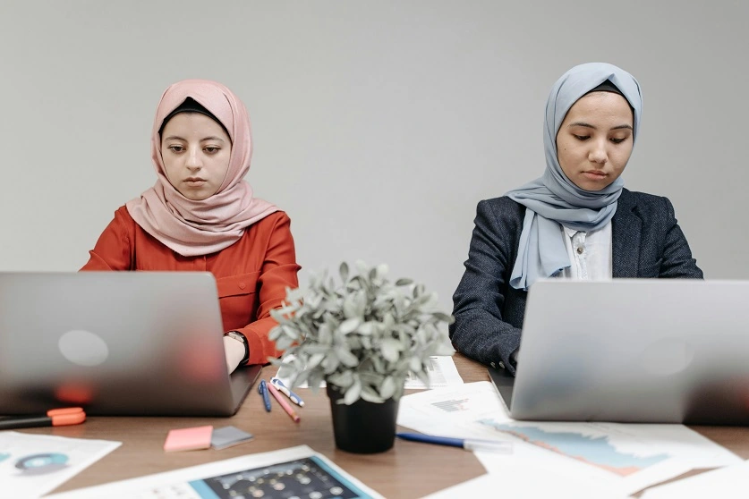 امرأتان تعملان أمام اللابتوب.