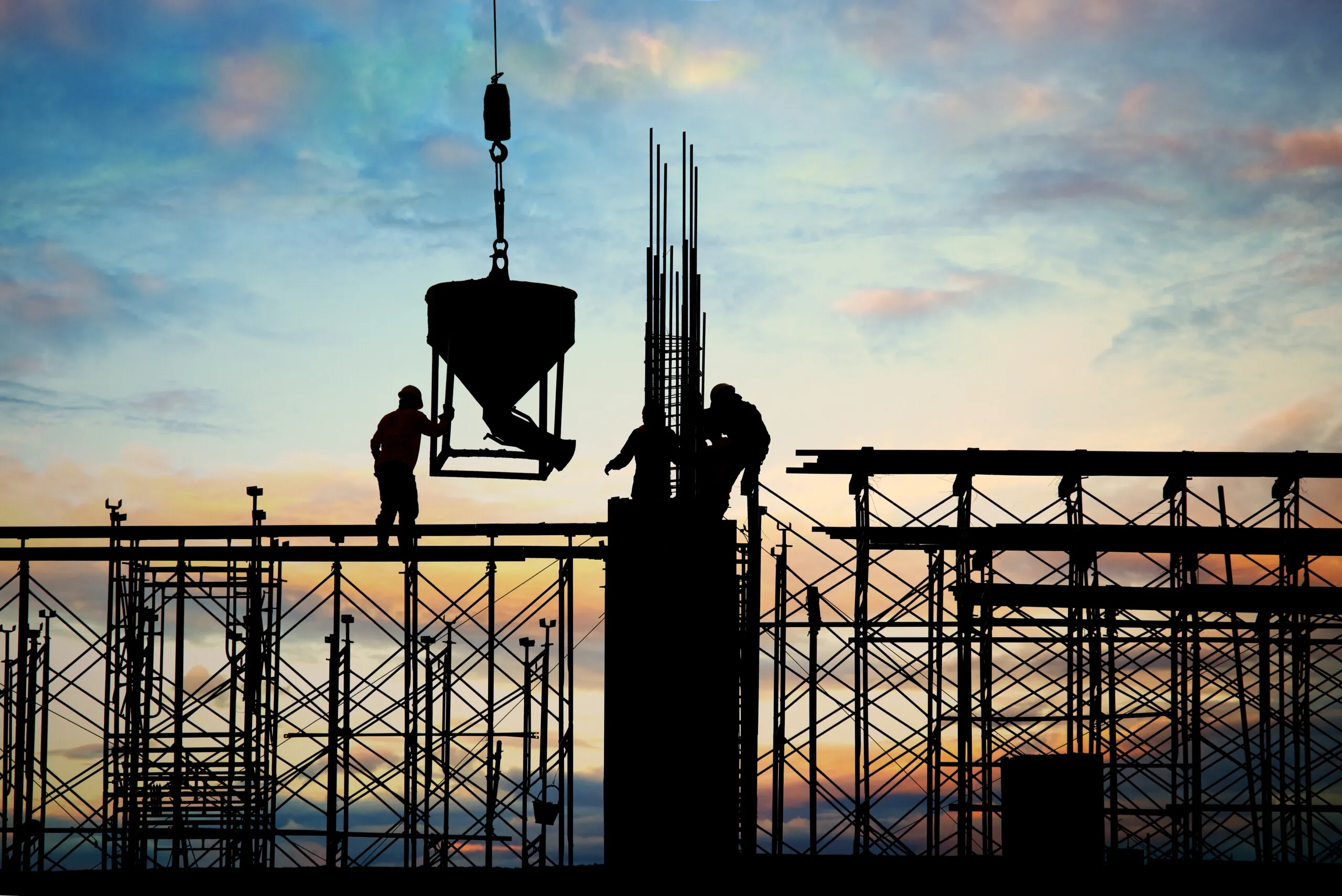 Silhouettes of workers on a construction site.