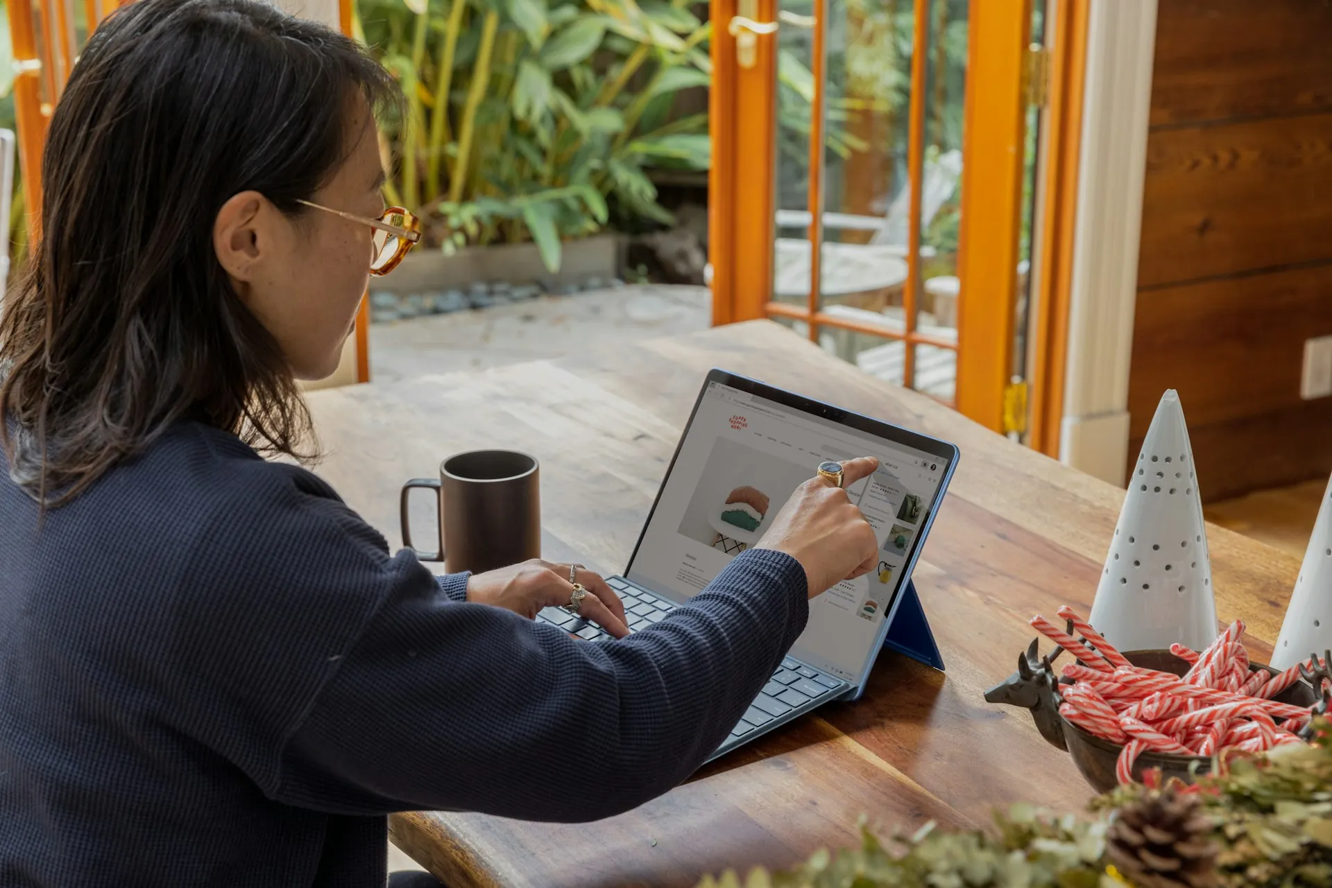 Una donna che lavora al proprio computer portatile mentre si trova in un caffè.