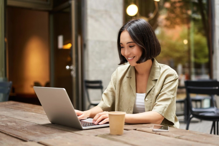 カフェでパソコンを使って作業する女性