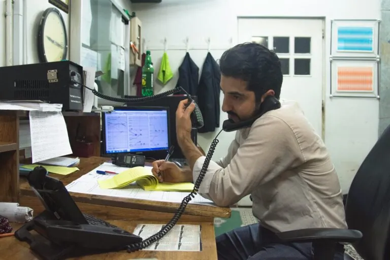 Uomo che lavora alla scrivania mentre è al telefono