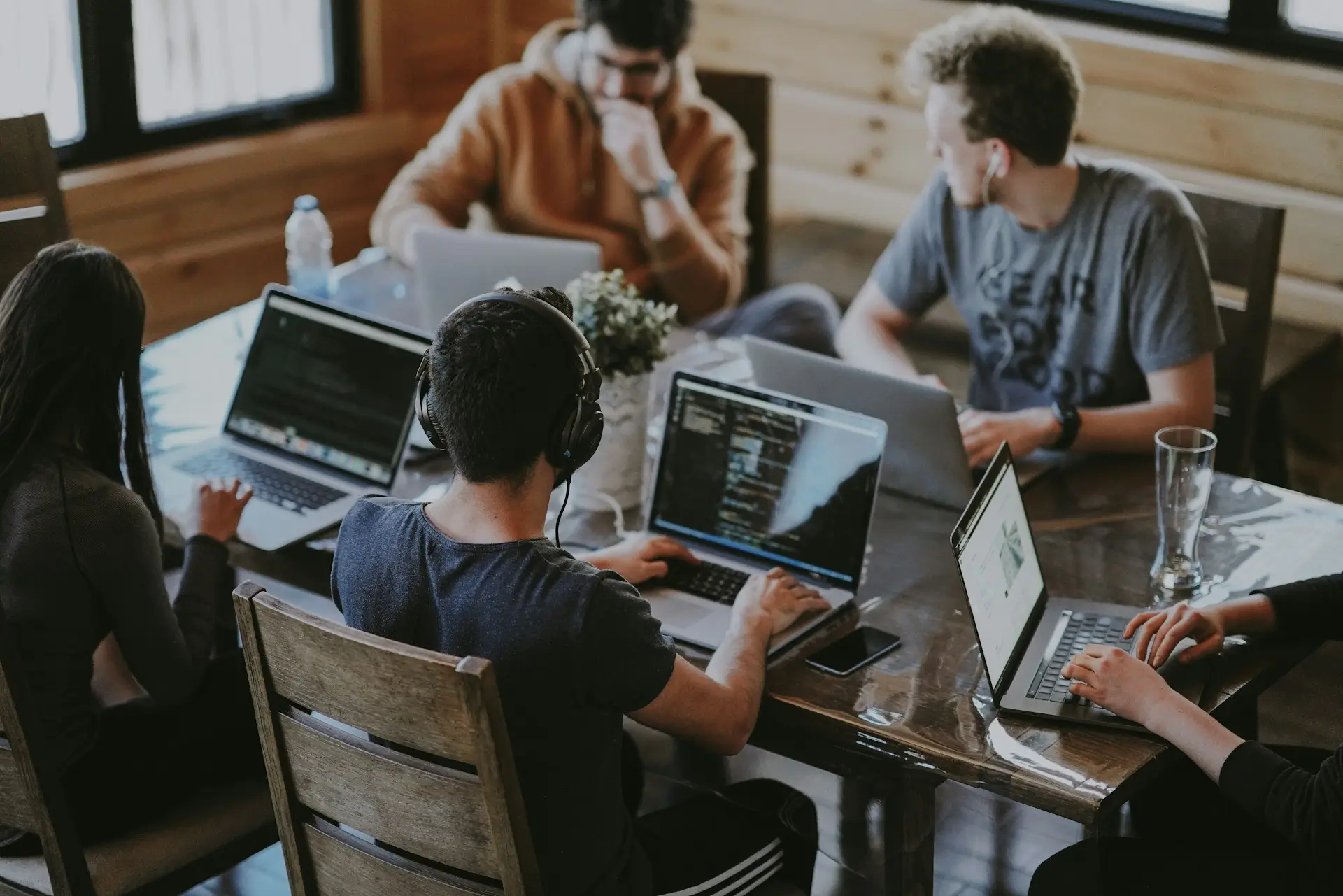 Grupp di ragazzi che lavorano allo stesso tavolo con il loro portatile.