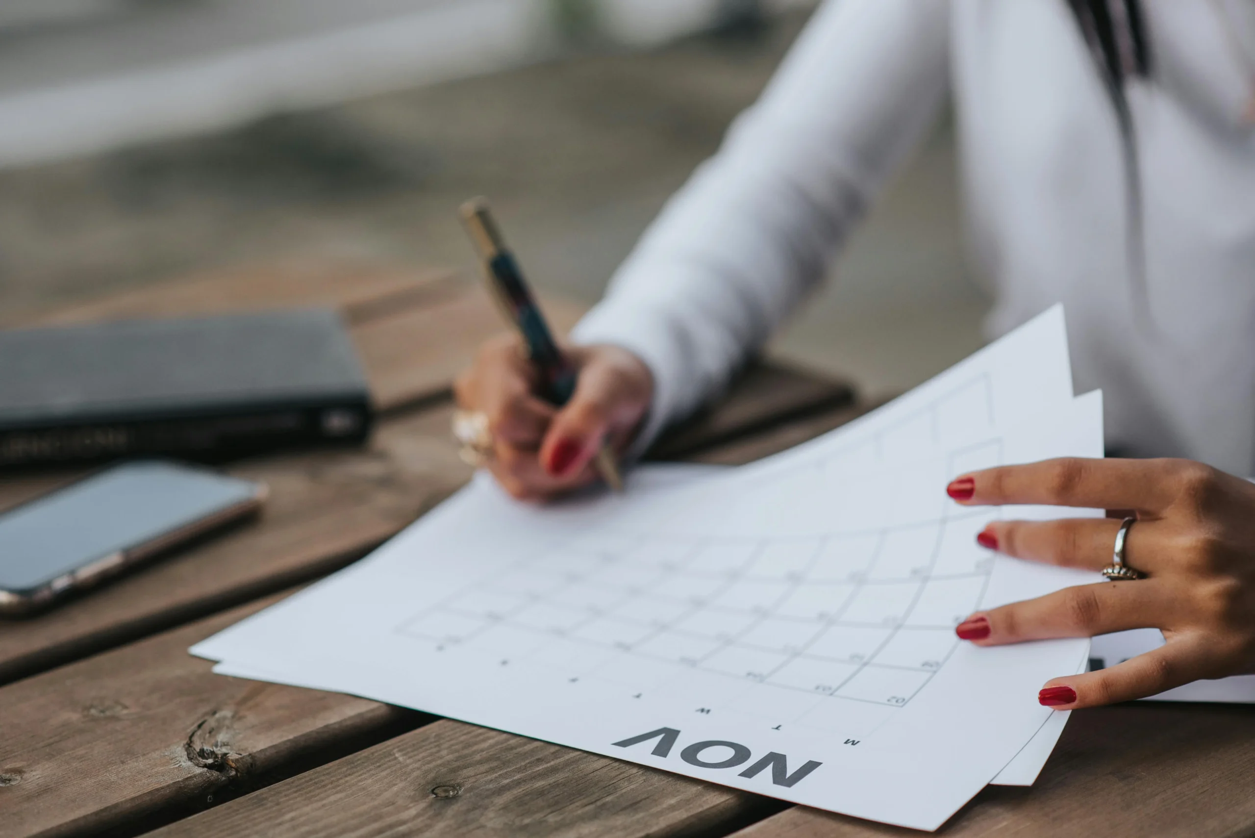 Mani che annotano un calendario.