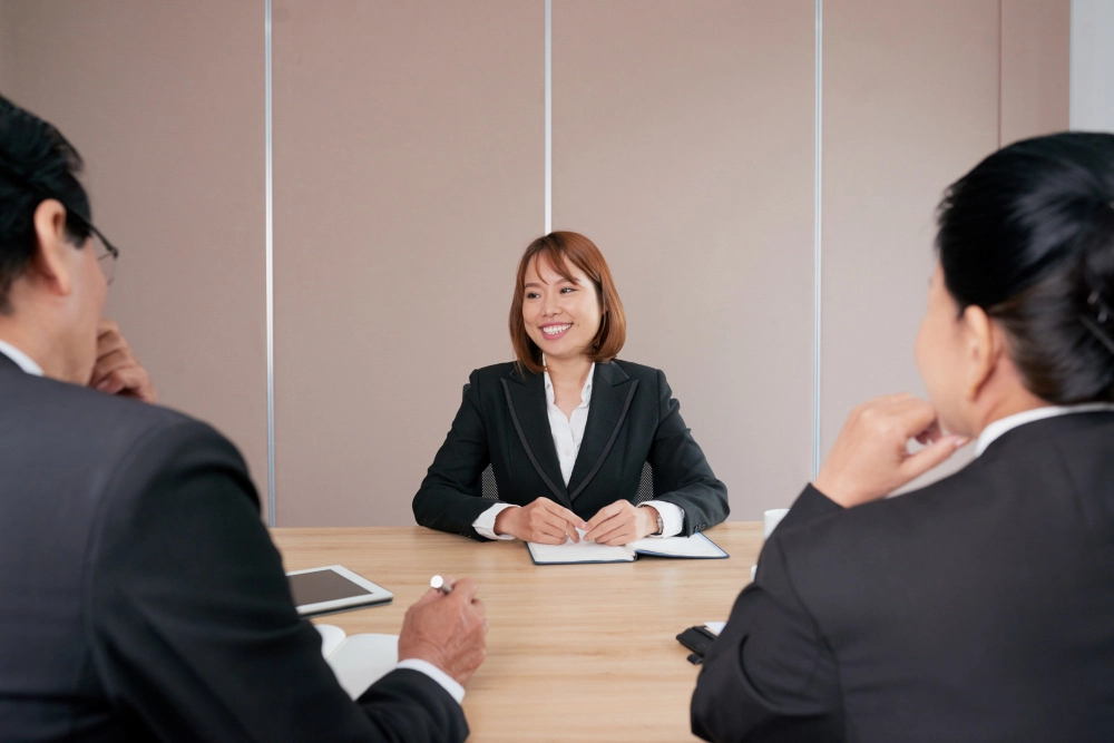 自信的亚洲女商务人士坐在办公室会议中微笑