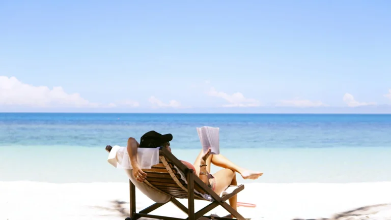 Mulher aproveitando suas férias laborais no Brasil e lendo na praia